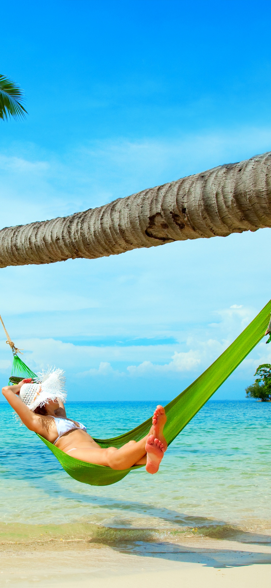 Woman in White Shirt and Green Shorts Lying on Hammock Under Coconut Tree During Daytime. Wallpaper in 1125x2436 Resolution