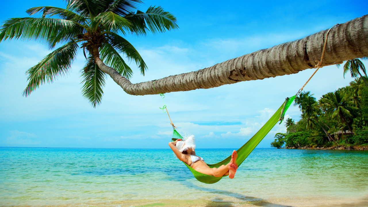 Woman in White Shirt and Green Shorts Lying on Hammock Under Coconut Tree During Daytime. Wallpaper in 1280x720 Resolution