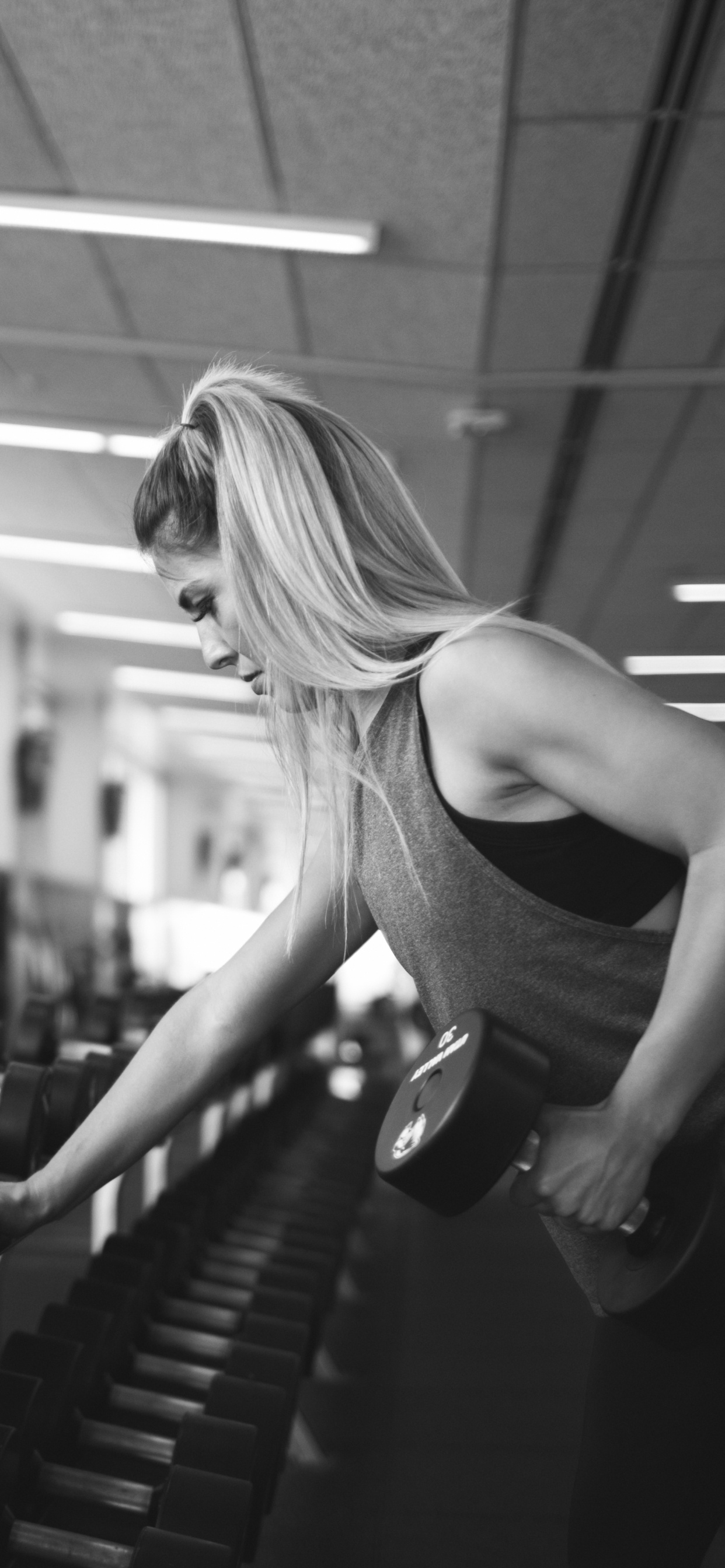 Frau im Schwarzen Tanktop Macht Sport. Wallpaper in 1242x2688 Resolution