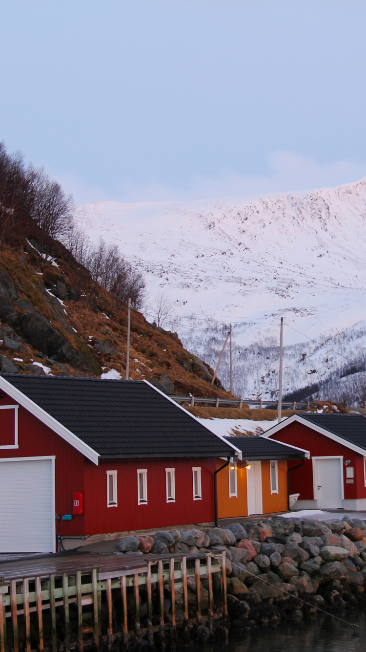 Red and White Wooden House Near Body of Water and Mountains During Daytime. Wallpaper in 750x1334 Resolution