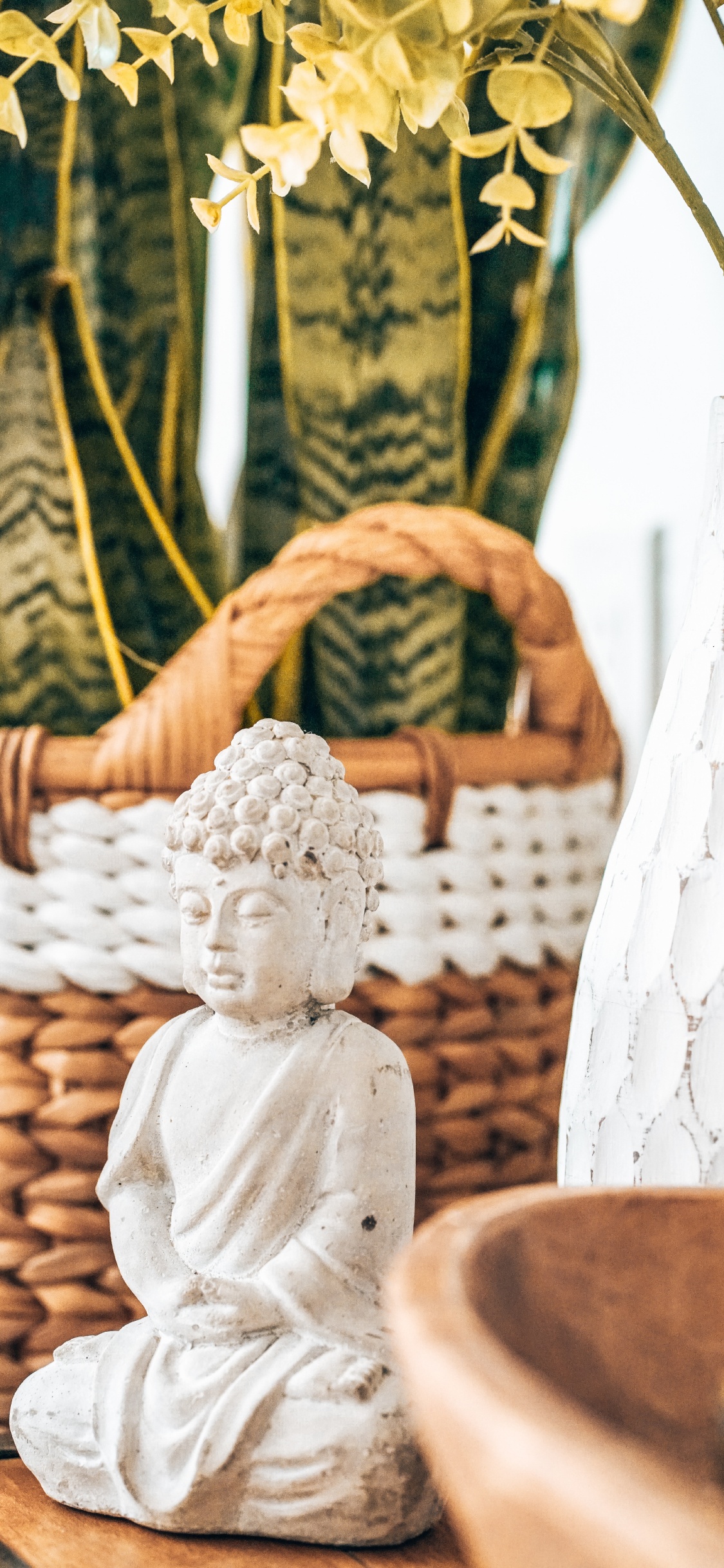 Angel Ceramic Figurine on Brown Woven Basket. Wallpaper in 1125x2436 Resolution