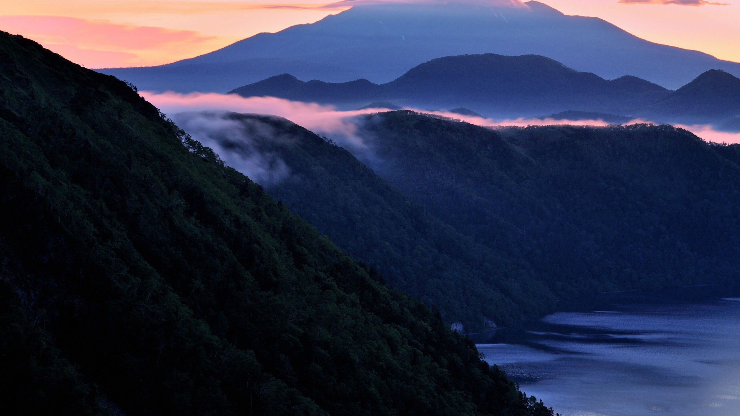 Montagnes Vertes Près D'un Plan D'eau Pendant la Journée. Wallpaper in 2560x1440 Resolution