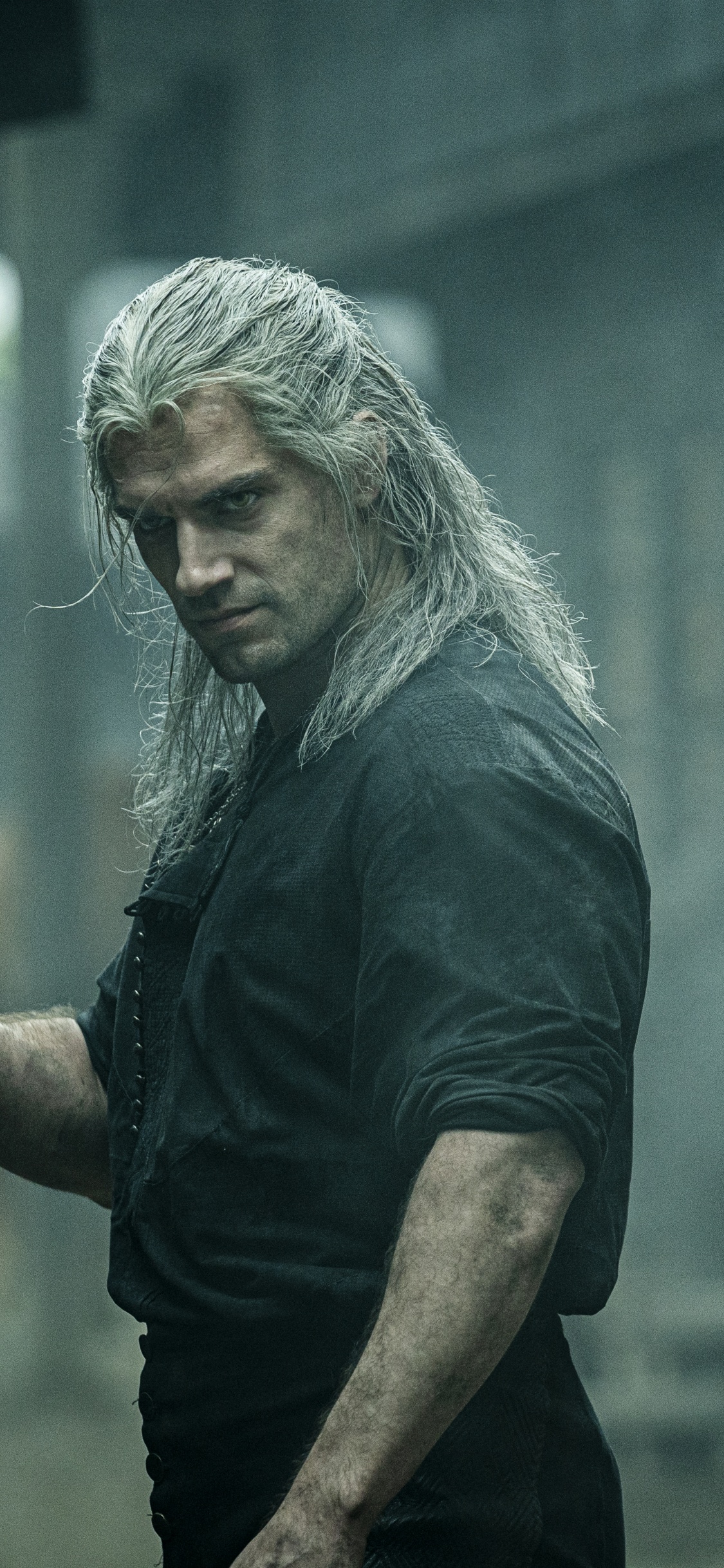 Mann im Schwarzen T-Shirt Mit Rundhalsausschnitt, Der Smartphone Hält. Wallpaper in 1125x2436 Resolution