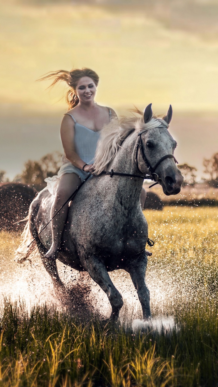 Femme en Débardeur Blanc Équitation Sur Cheval Blanc Sur Terrain D'herbe Verte Pendant la Journée. Wallpaper in 720x1280 Resolution