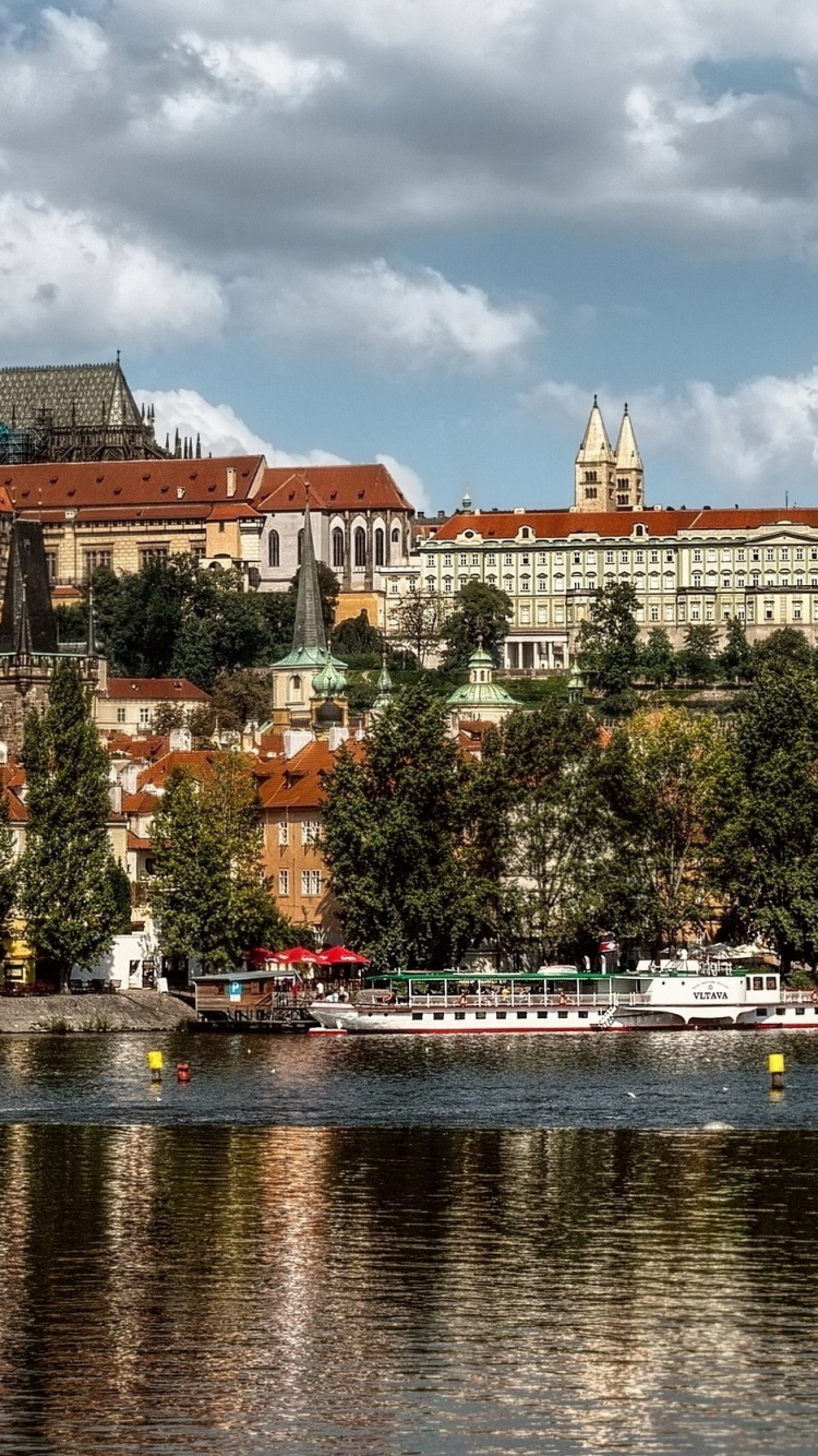 Brown Concrete Building Near Body of Water During Daytime. Wallpaper in 750x1334 Resolution
