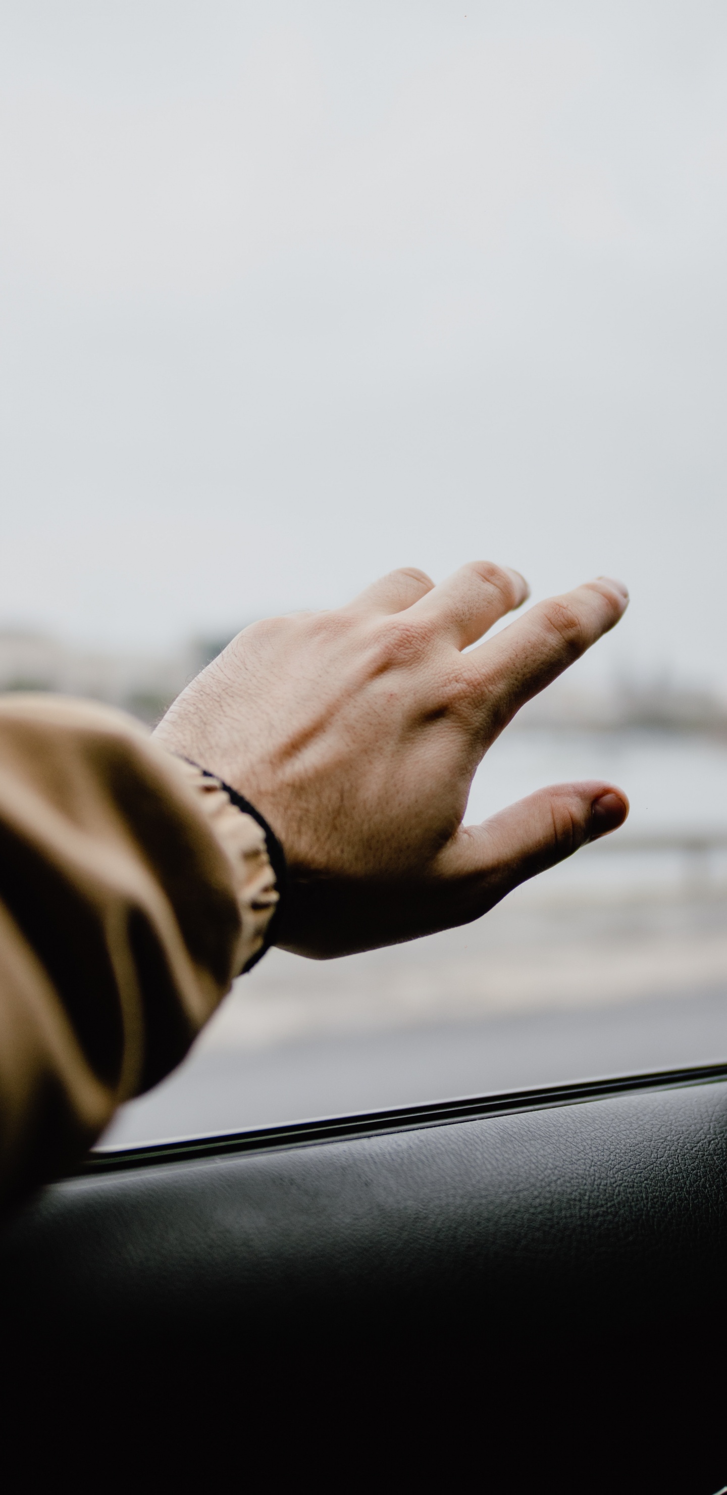 Persona en Chaqueta Marrón Sosteniendo la Ventanilla Del Coche. Wallpaper in 1440x2960 Resolution