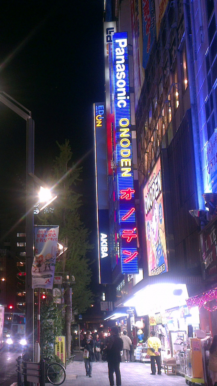 Voitures Sur Route Près Des Bâtiments Pendant la Nuit. Wallpaper in 750x1334 Resolution