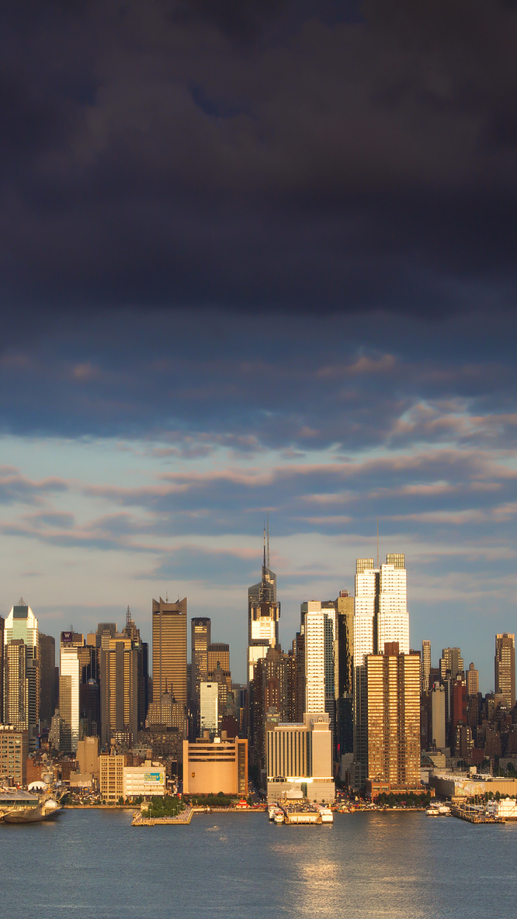 Skyline Der Stadt Über Gewässer Während Des Tages. Wallpaper in 750x1334 Resolution
