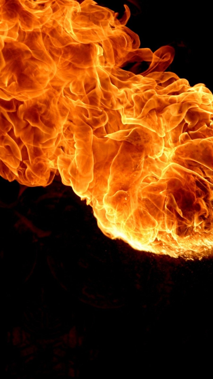 Orange Fire in Black Background. Wallpaper in 720x1280 Resolution