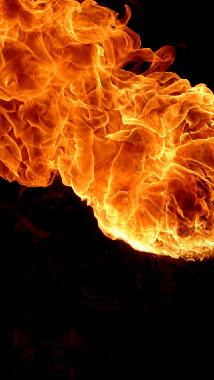 Orange Fire in Black Background. Wallpaper in 750x1334 Resolution