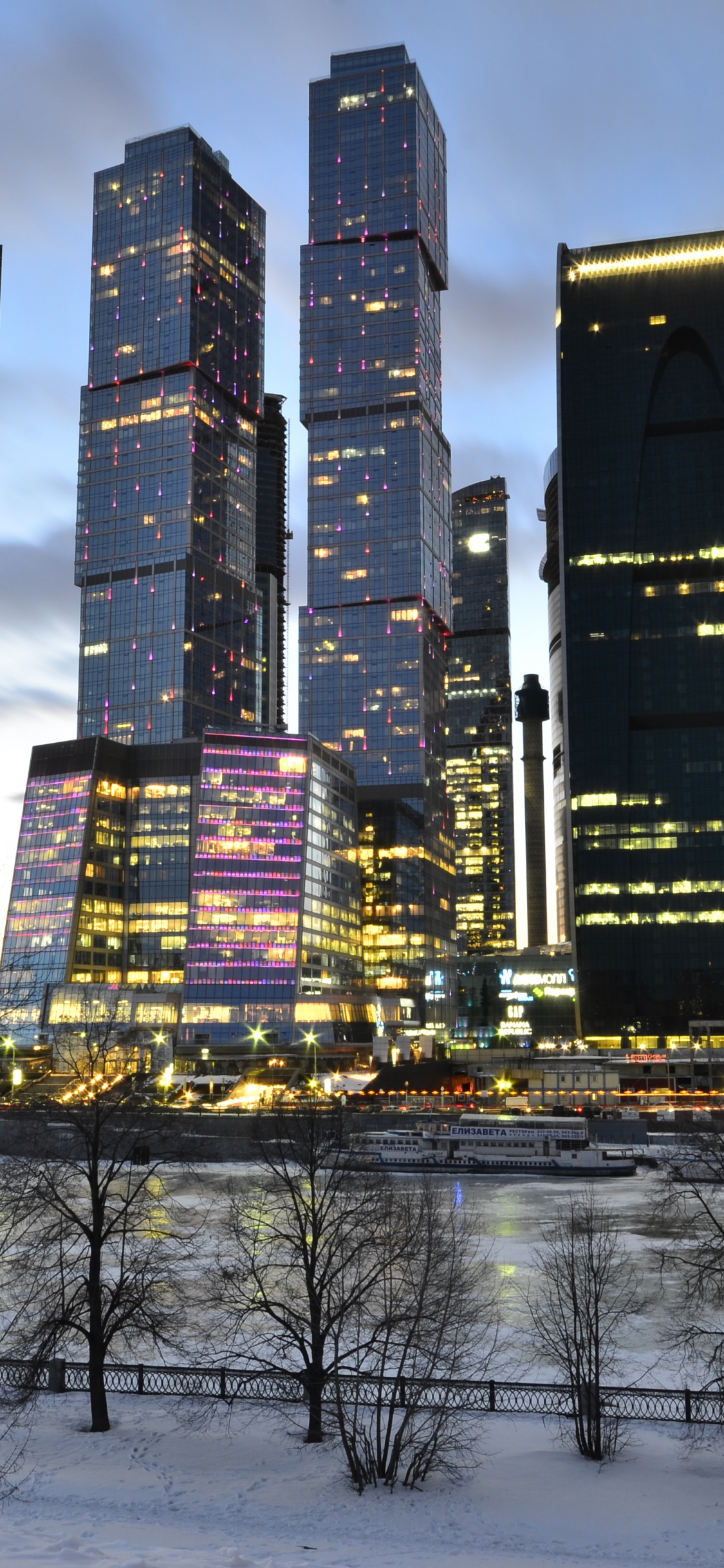 City Buildings Under Blue Sky During Night Time. Wallpaper in 1125x2436 Resolution