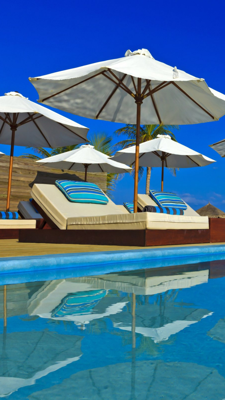 Brown and White Umbrella on Blue Water. Wallpaper in 750x1334 Resolution