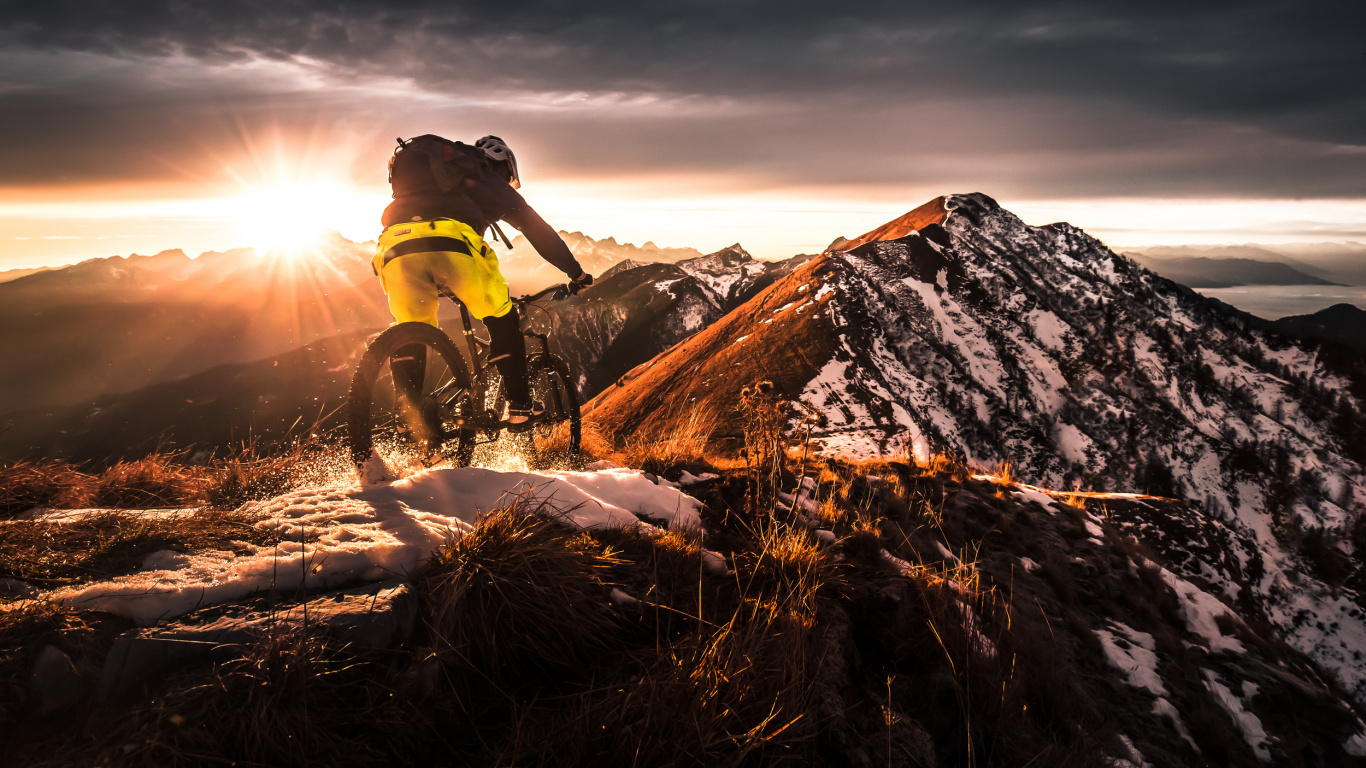 Mann in Grüner Jacke Und Schwarzer Hose, Der Währenddessen Auf Einem Schwarzen Motorrad Auf Einer Braunen Wiese Fährt. Wallpaper in 1366x768 Resolution