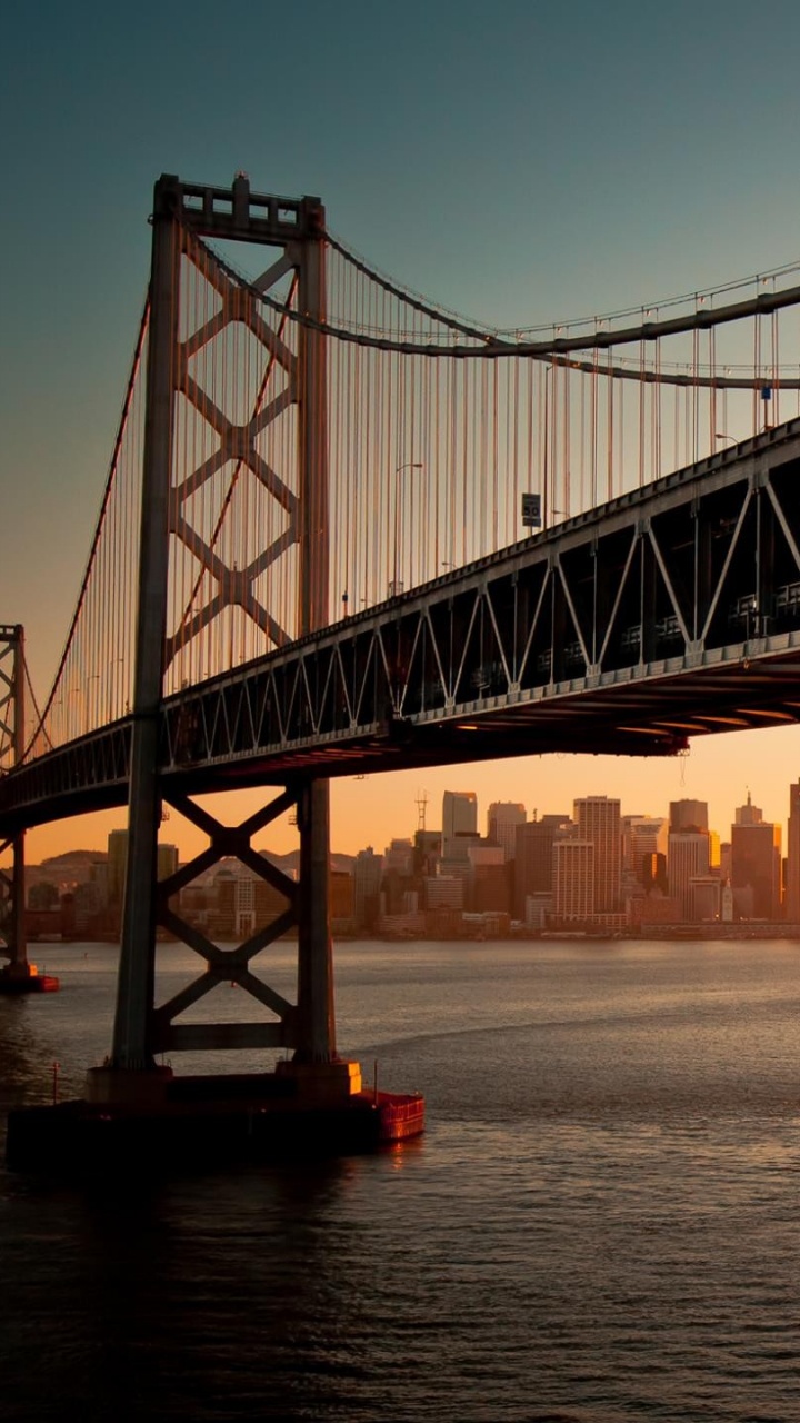 Puente Negro Sobre el Cuerpo de Agua Durante la Puesta de Sol. Wallpaper in 720x1280 Resolution