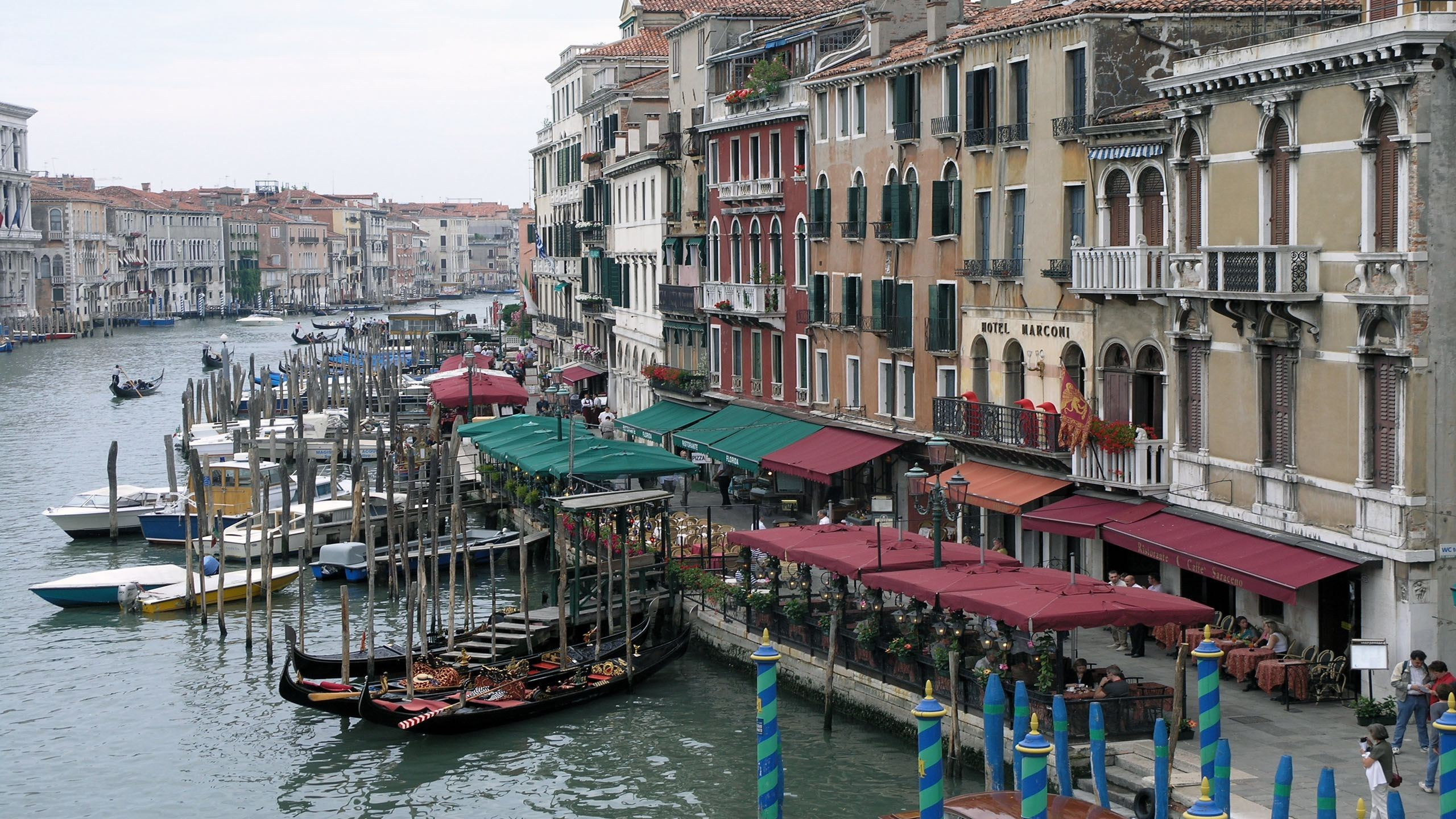 Menschen, Die Tagsüber Auf Einem Holzdock in Der Nähe Von Gebäuden Gehen. Wallpaper in 2560x1440 Resolution