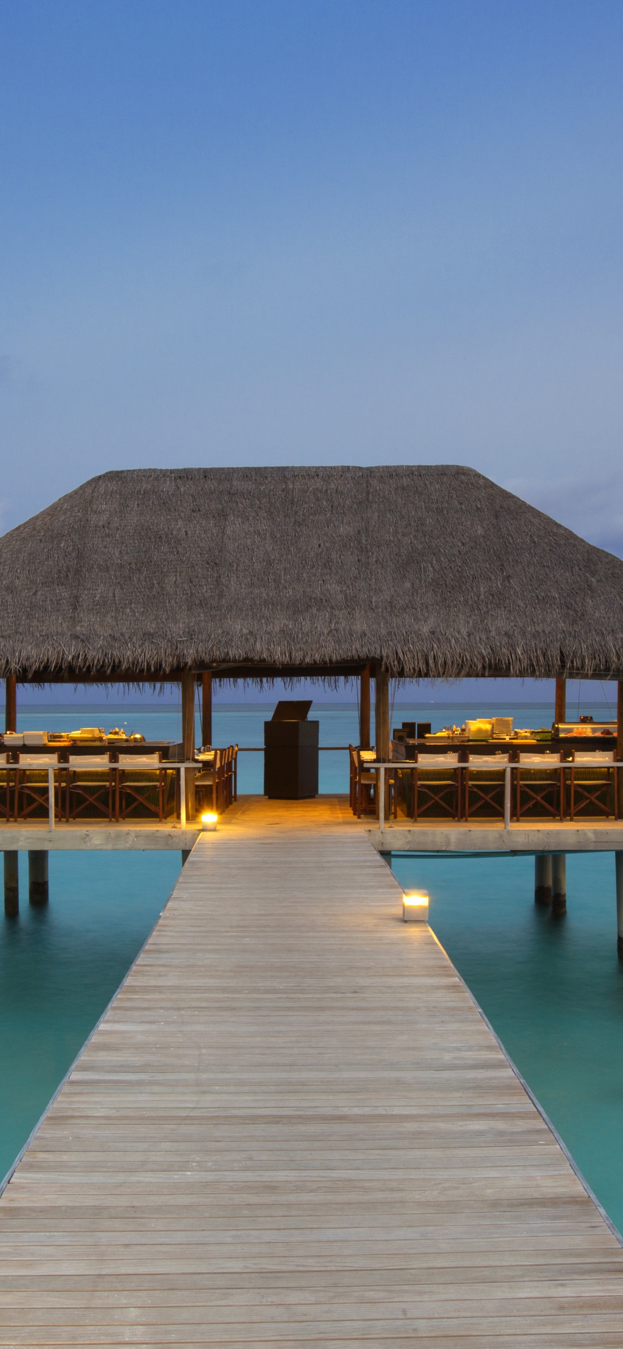 Brown Wooden Beach House on Blue Sea Under Blue Sky During Daytime. Wallpaper in 1242x2688 Resolution