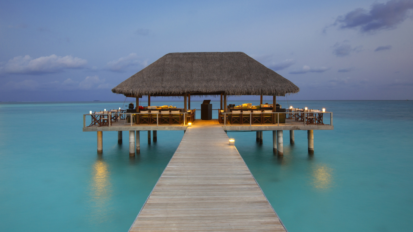 Brown Wooden Beach House on Blue Sea Under Blue Sky During Daytime. Wallpaper in 1366x768 Resolution