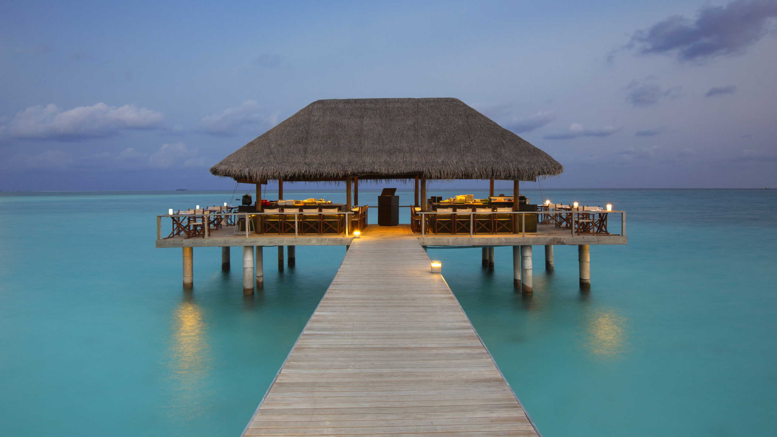 Brown Wooden Beach House on Blue Sea Under Blue Sky During Daytime. Wallpaper in 2560x1440 Resolution