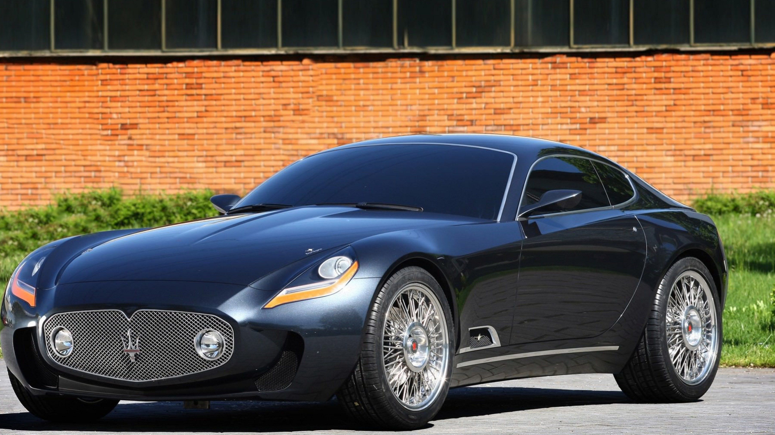 Black Porsche 911 Parked Near Brown Brick Wall. Wallpaper in 2560x1440 Resolution