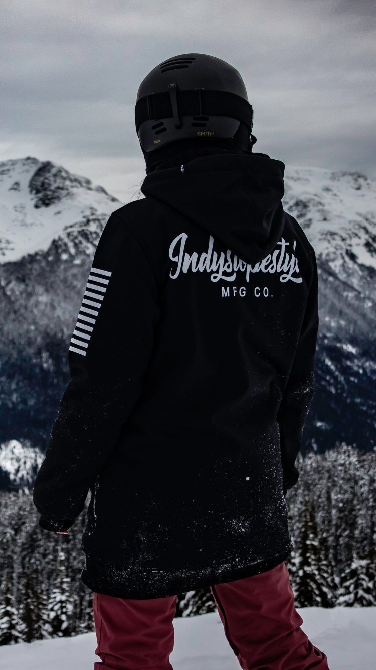 Man in Black Jacket and Red Pants Standing on Snow Covered Ground. Wallpaper in 750x1334 Resolution