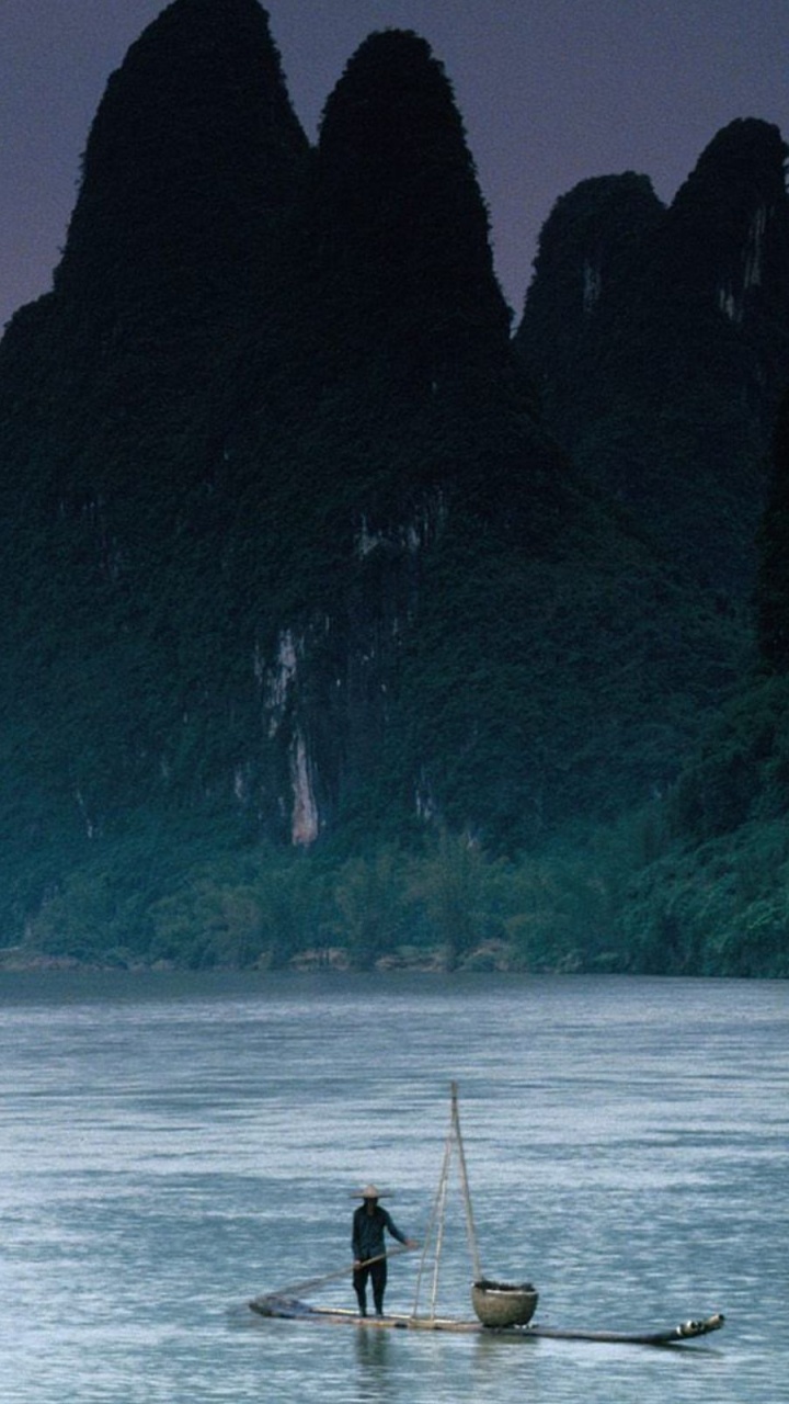 Man in Black Shirt and Black Shorts Standing on Boat on Sea During Daytime. Wallpaper in 720x1280 Resolution