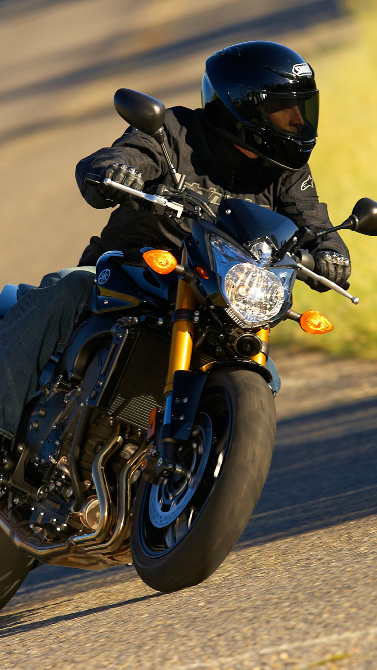 Hombre de Chaqueta Negra Montando en Motocicleta Negra en la Carretera Durante el Día. Wallpaper in 750x1334 Resolution