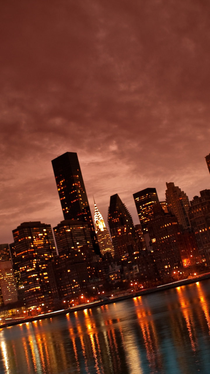 City Skyline Across Body of Water During Night Time. Wallpaper in 720x1280 Resolution