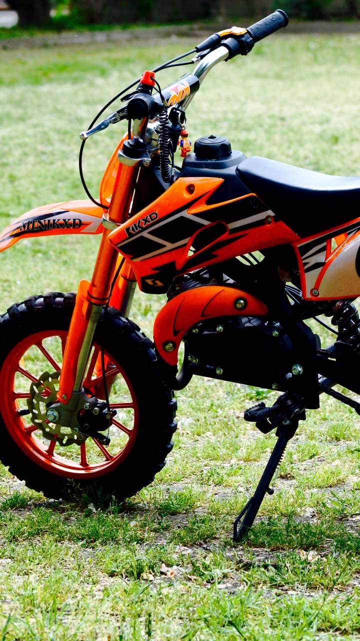 Vélo de Sport Orange et Noir Sur Terrain D'herbe Verte Pendant la Journée. Wallpaper in 720x1280 Resolution