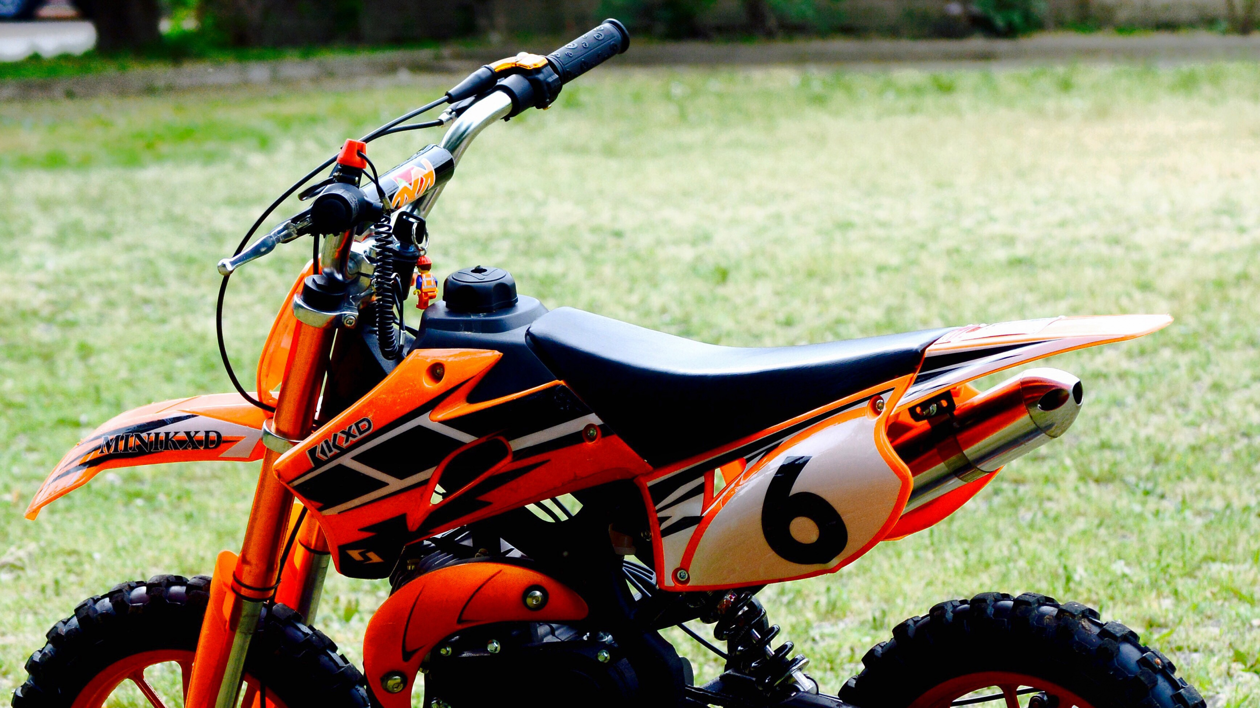 Orange and Black Sports Bike on Green Grass Field During Daytime. Wallpaper in 2560x1440 Resolution