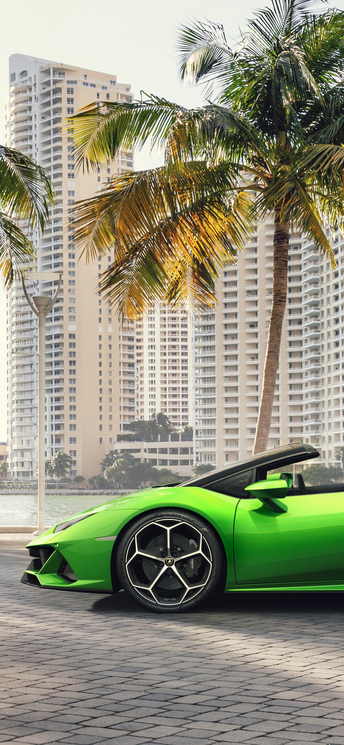 Green Ferrari Sports Car on Road During Daytime. Wallpaper in 1125x2436 Resolution