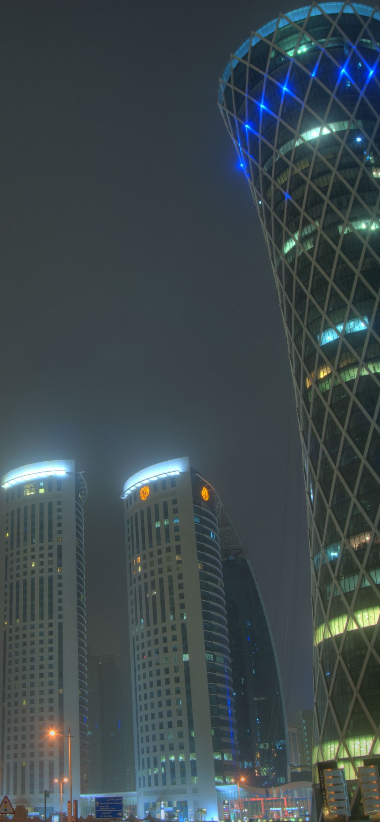 Edificio Alto Iluminado en Azul Durante la Noche. Wallpaper in 1242x2688 Resolution