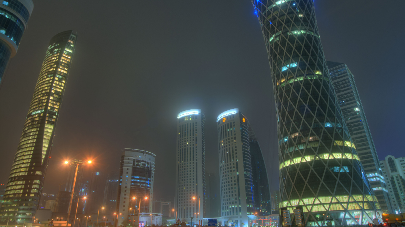 Blau Beleuchtetes Hochhaus Während Der Nacht. Wallpaper in 1366x768 Resolution