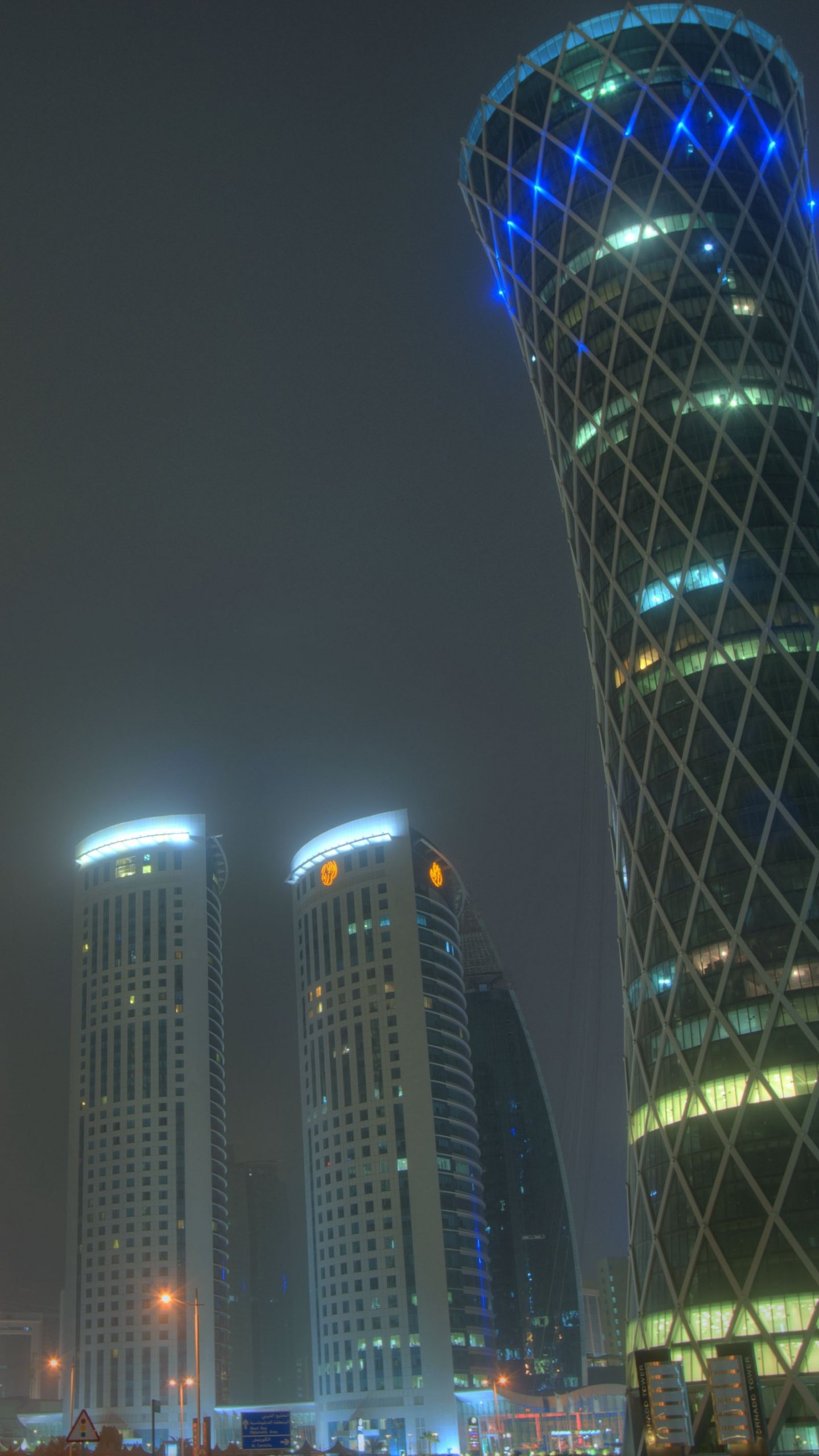 Blau Beleuchtetes Hochhaus Während Der Nacht. Wallpaper in 1440x2560 Resolution