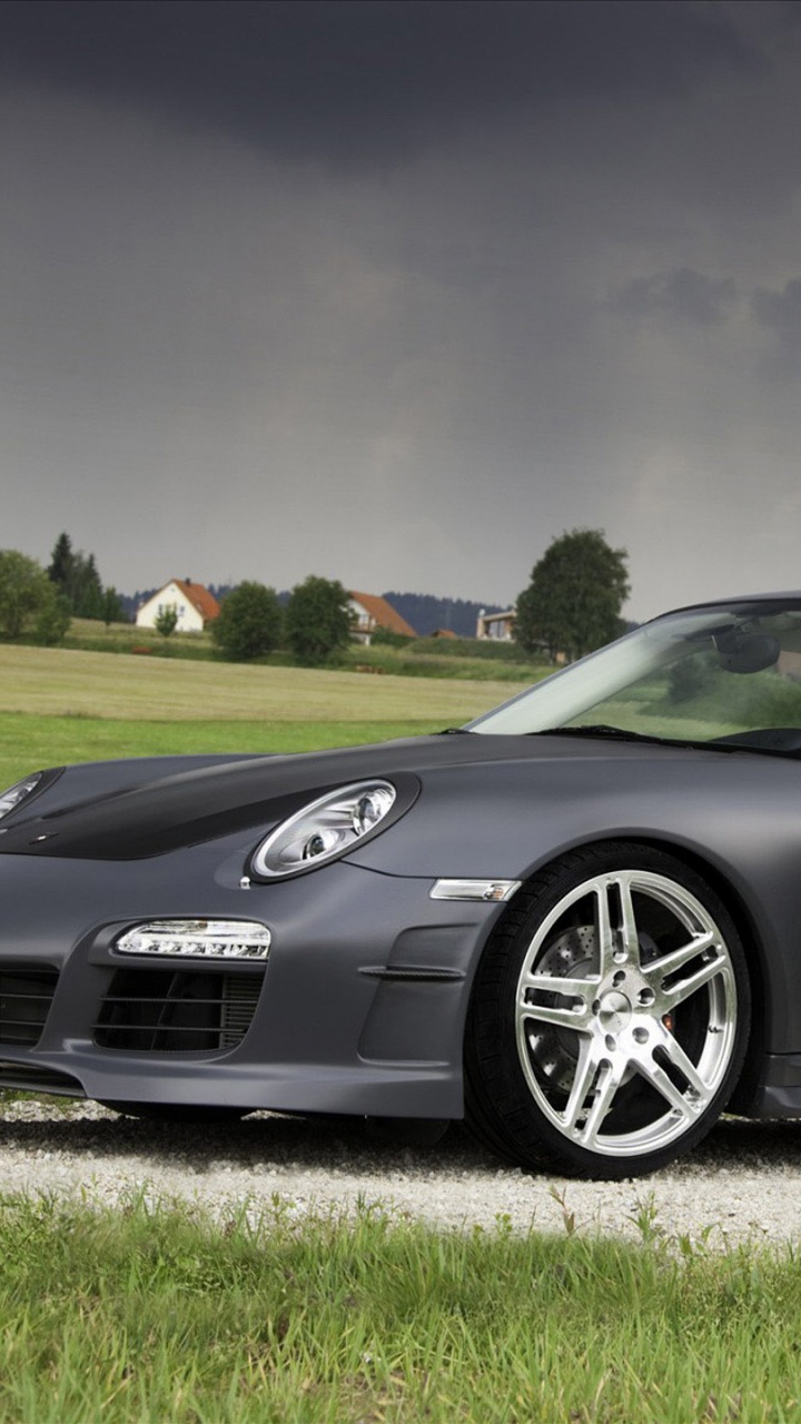 Schwarzer Porsche 911 Unterwegs Unter Blauem Himmel. Wallpaper in 720x1280 Resolution