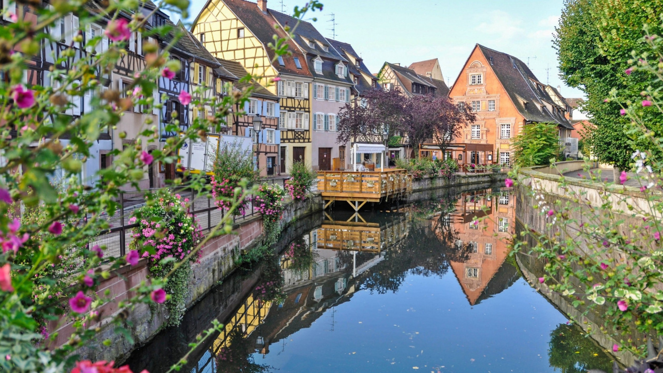 Brown and White Concrete Houses Beside Body of Water During Daytime. Wallpaper in 1366x768 Resolution