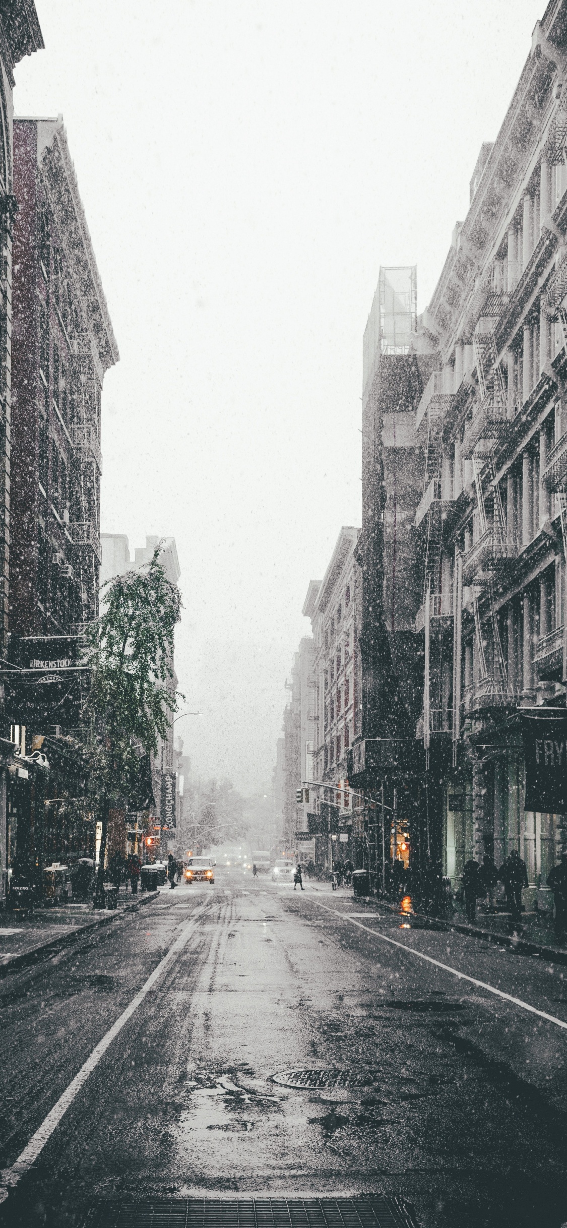 Gray Concrete Road Between High Rise Buildings. Wallpaper in 1125x2436 Resolution