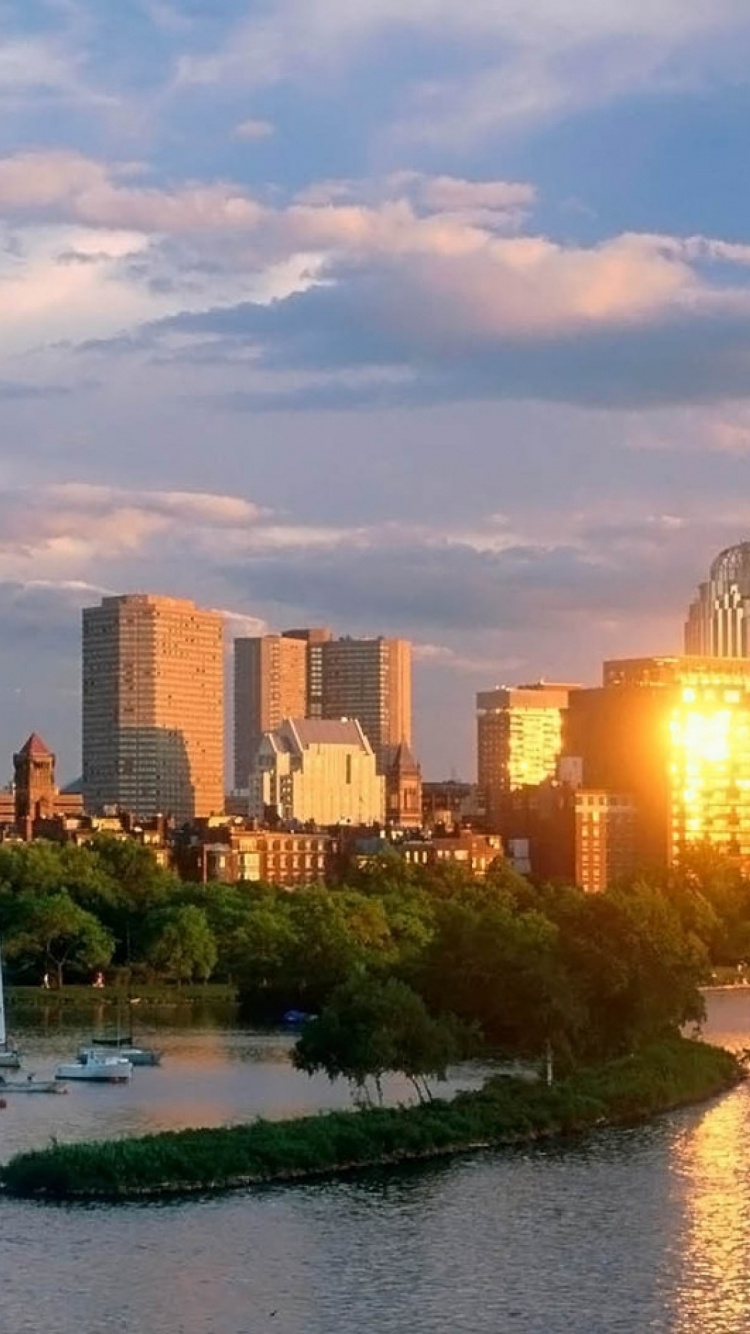 Weißes Segelboot Auf Dem Fluss in Der Nähe Von Stadtgebäuden Tagsüber. Wallpaper in 750x1334 Resolution