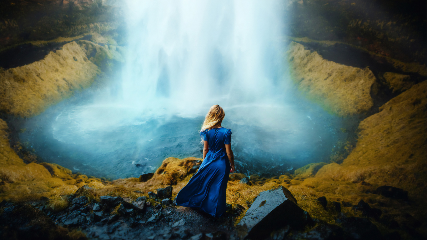 Frau in Blauer Jacke, Die Tagsüber Auf Einem Felsen in Der Nähe Von Wasserfällen Sitzt. Wallpaper in 1366x768 Resolution