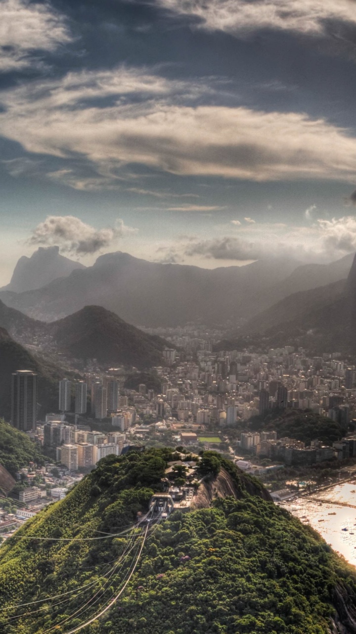 Campo de Hierba Verde Cerca de la Montaña Bajo Nubes Blancas Durante el Día. Wallpaper in 720x1280 Resolution