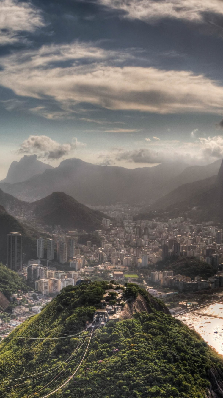 Campo de Hierba Verde Cerca de la Montaña Bajo Nubes Blancas Durante el Día. Wallpaper in 750x1334 Resolution