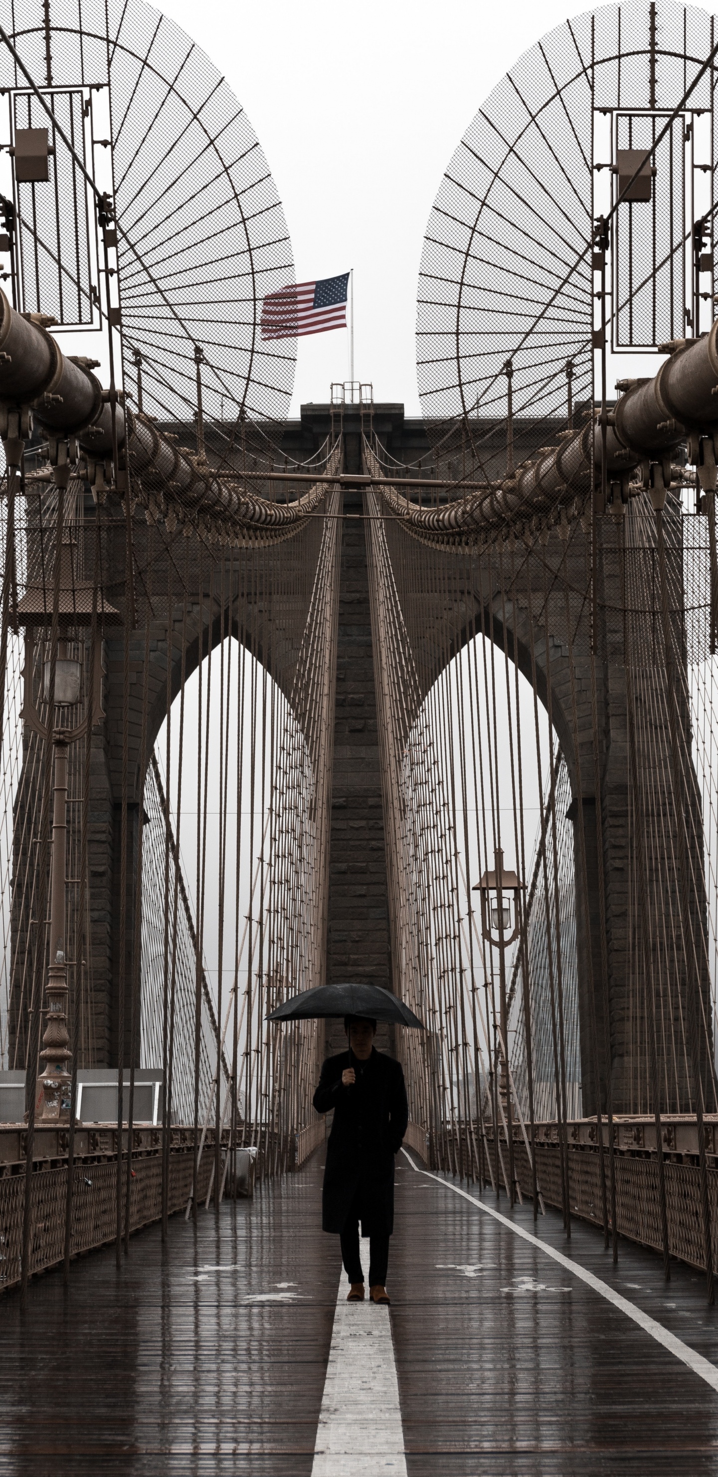 Mujer de Chaqueta Negra y Pantalón Negro Caminando Sobre el Puente Durante el Día. Wallpaper in 1440x2960 Resolution