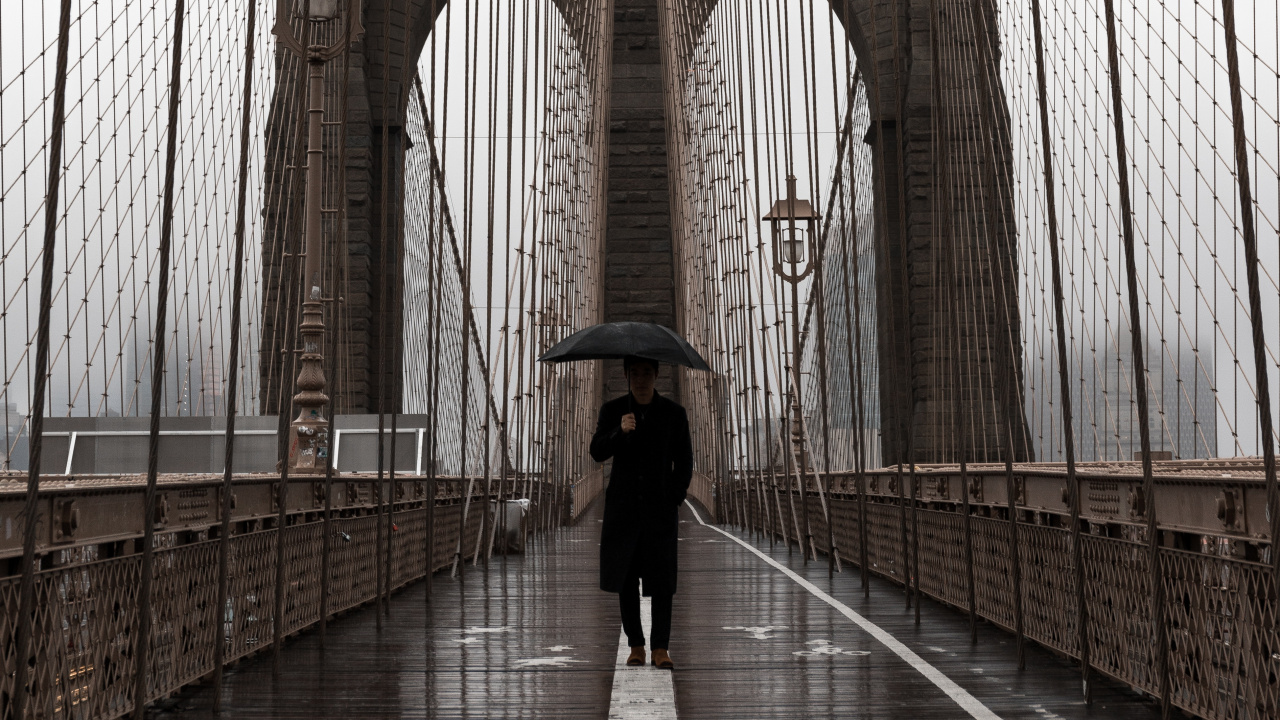 Woman in Black Jacket and Black Pants Walking on Bridge During Daytime. Wallpaper in 1280x720 Resolution