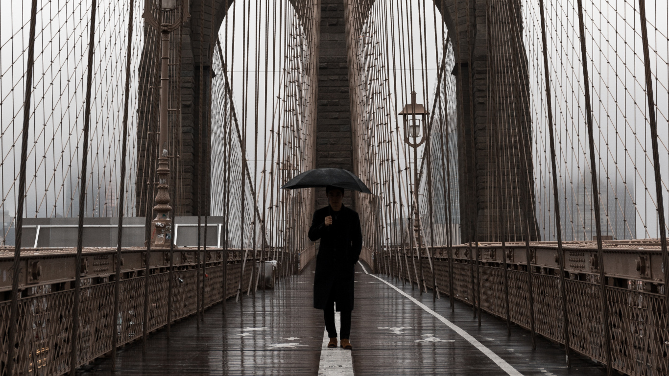 Woman in Black Jacket and Black Pants Walking on Bridge During Daytime. Wallpaper in 1366x768 Resolution
