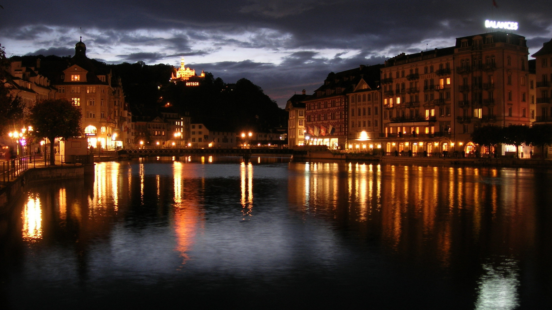 Edificio de Hormigón Marrón Cerca Del Cuerpo de Agua Durante la Noche. Wallpaper in 1920x1080 Resolution