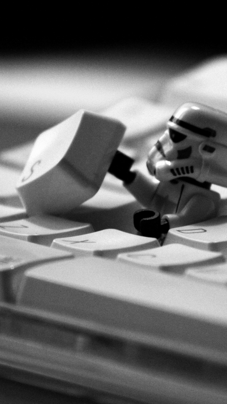 Weiße Und Schwarze Lego-Minifigur Auf Weißer Computertastatur. Wallpaper in 750x1334 Resolution