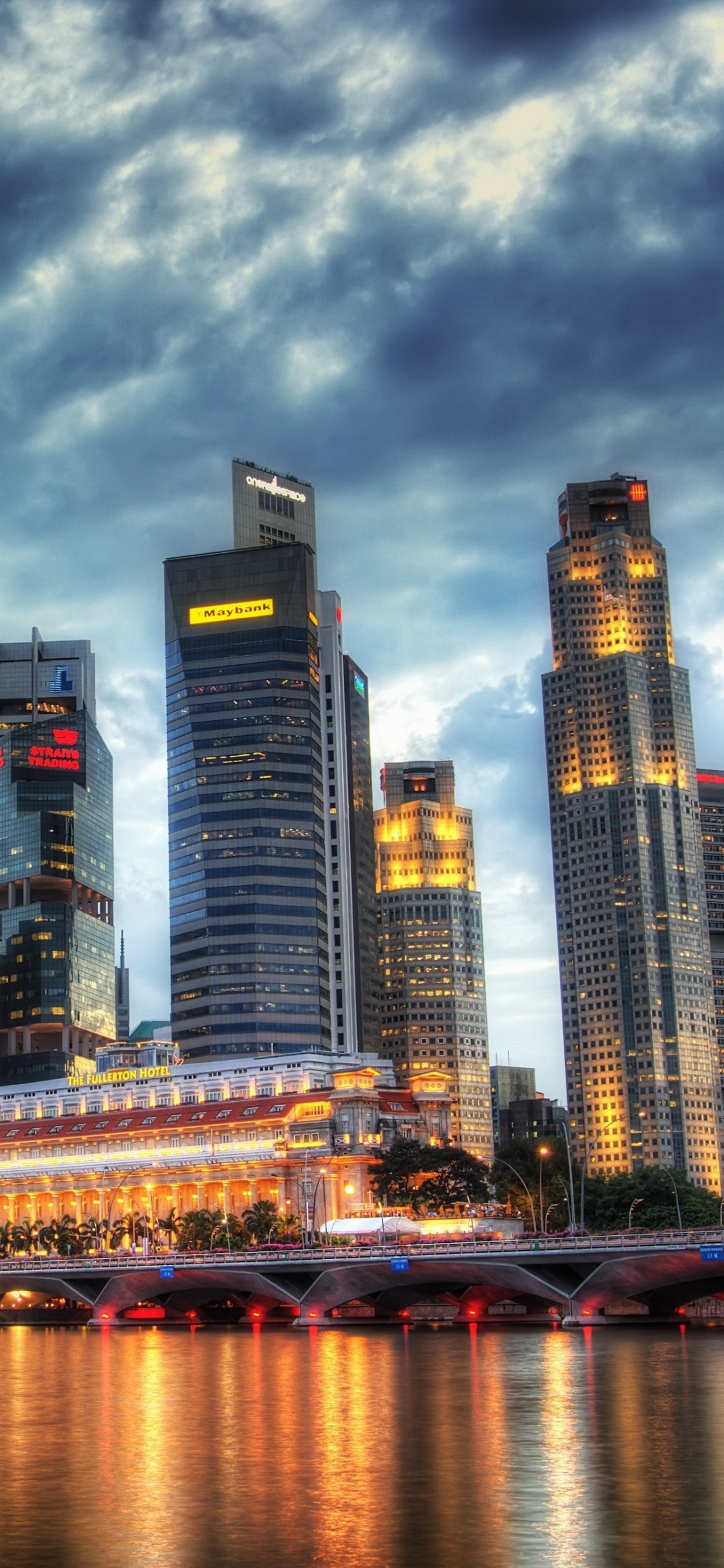 Horizonte de la Ciudad a Través Del Cuerpo de Agua Durante la Noche.. Wallpaper in 1125x2436 Resolution