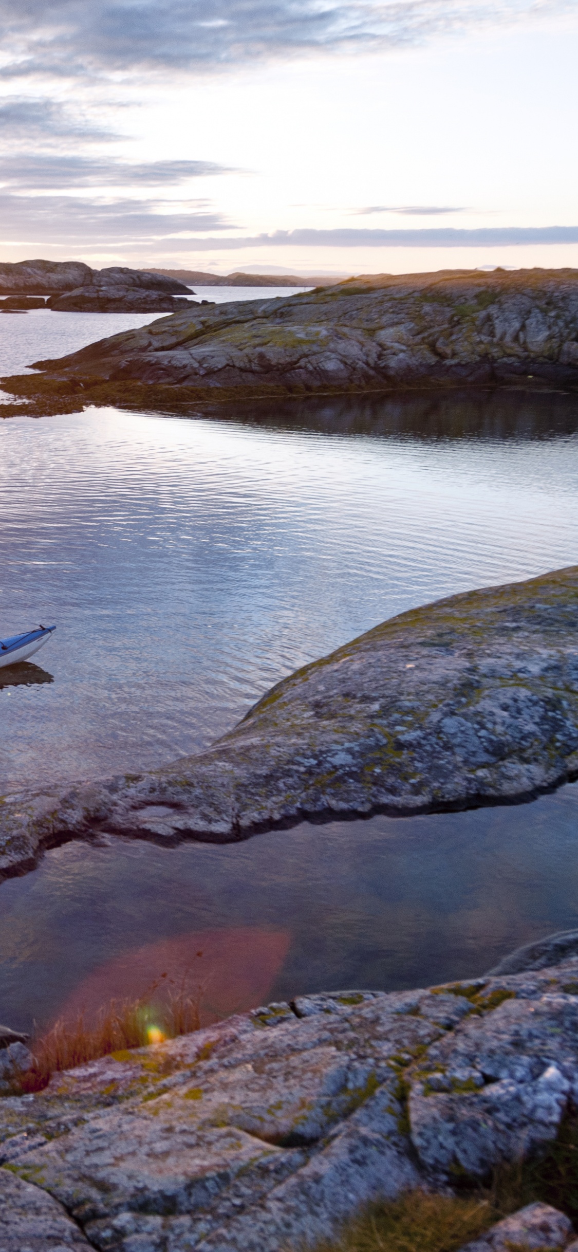 2 Hombres Viajando en Bote Durante la Puesta de Sol. Wallpaper in 1125x2436 Resolution