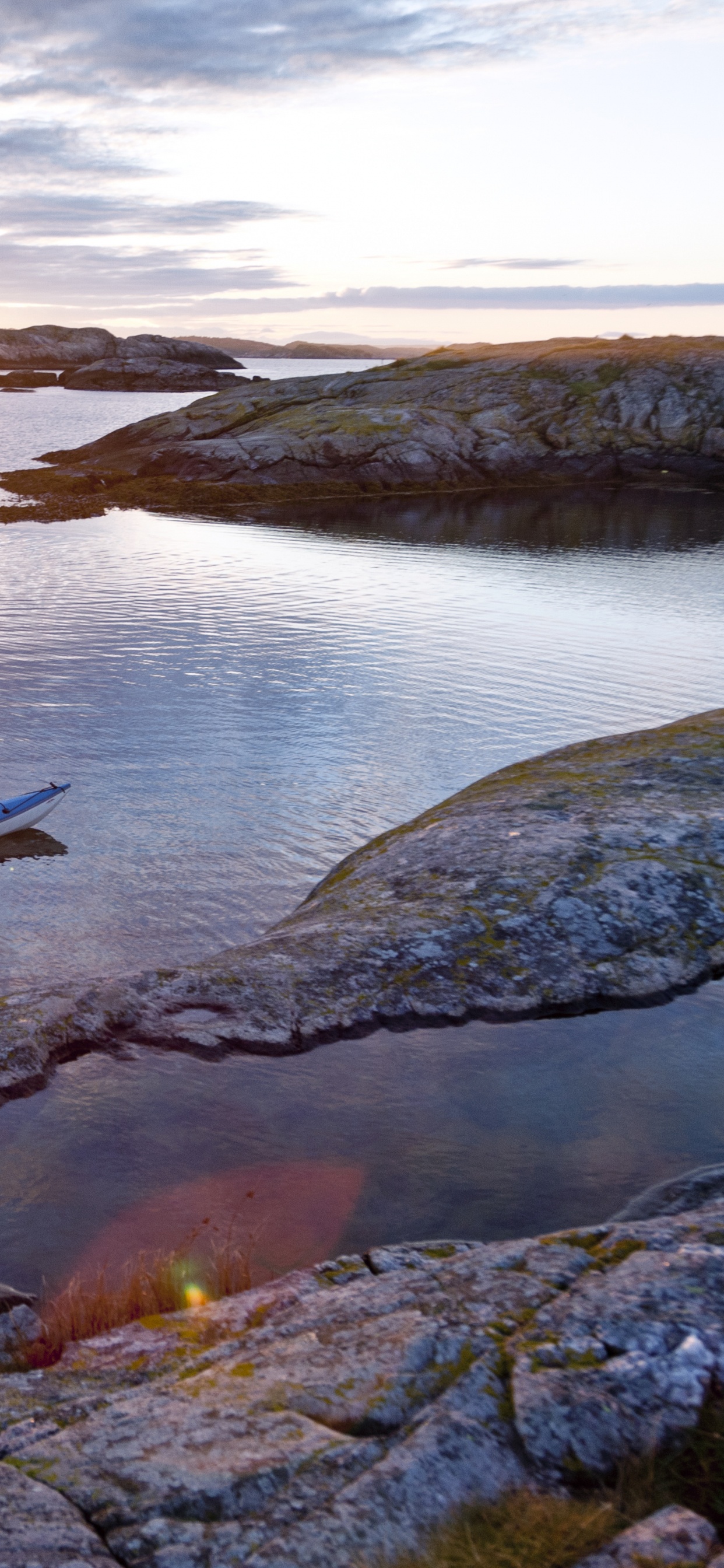 2 Hombres Viajando en Bote Durante la Puesta de Sol. Wallpaper in 1242x2688 Resolution