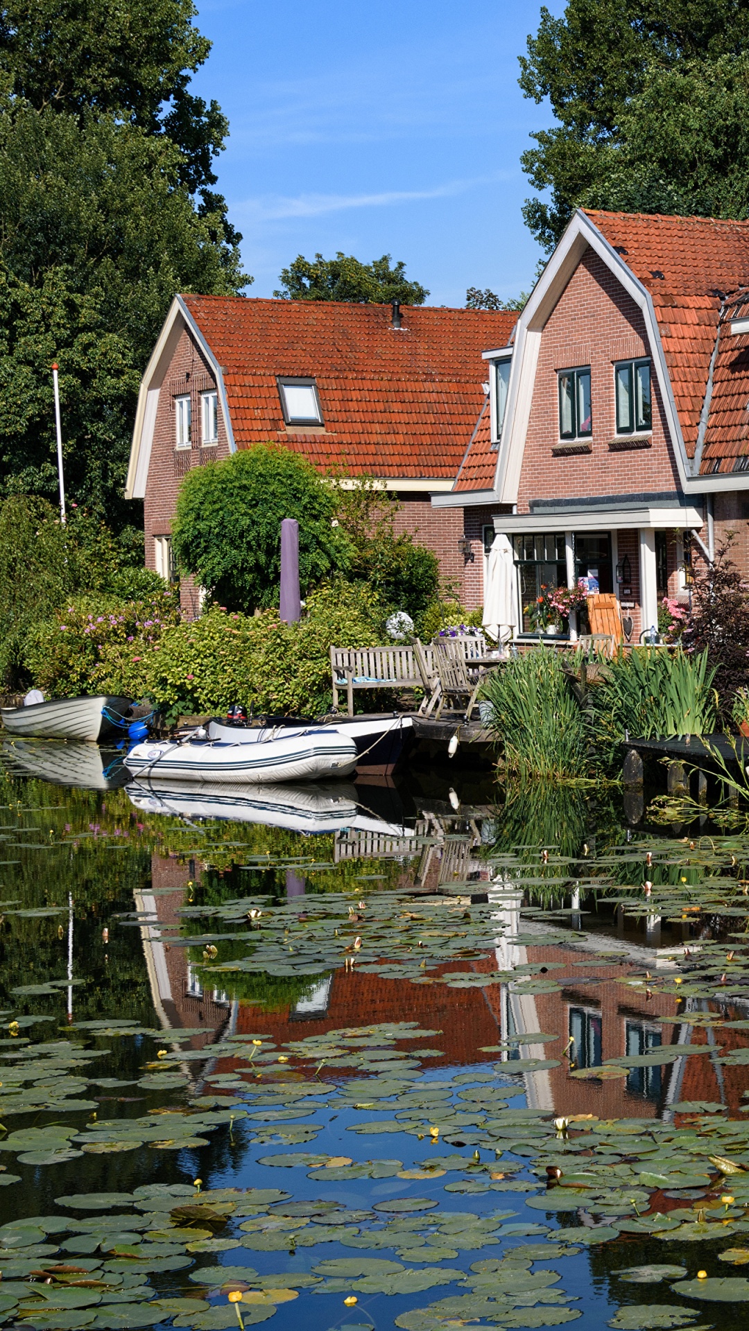 White and Brown Concrete House Near Body of Water During Daytime. Wallpaper in 1080x1920 Resolution