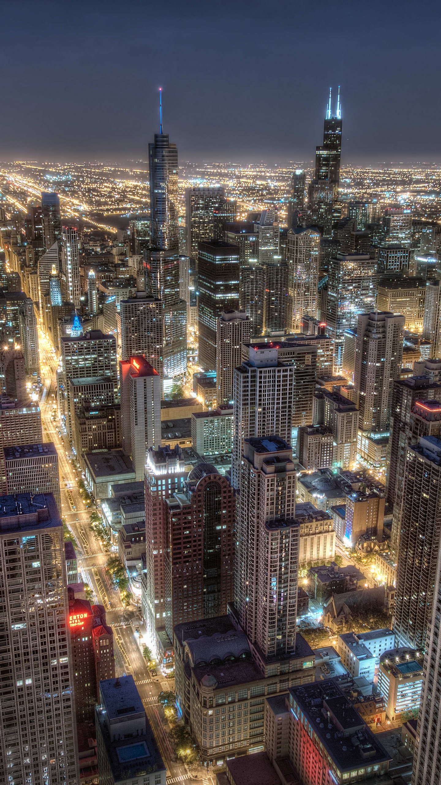 Vista Aérea de Los Edificios de la Ciudad Durante la Noche.. Wallpaper in 1440x2560 Resolution